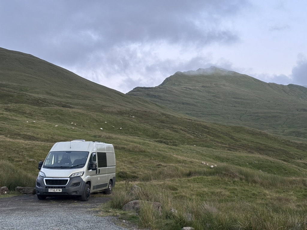 A campervan parked beneath the mountains